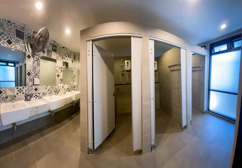 a bathroom with two sinks and two mirrors at Capzule Bed Phuket in Phuket