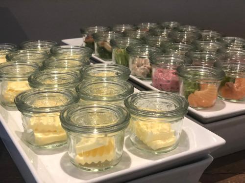 a bunch of jars of food on a tray at Hotel Leegerpark in Greetsiel