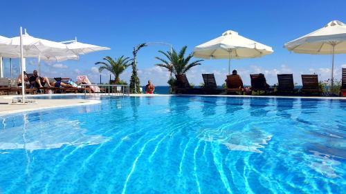 uma grande piscina com cadeiras e guarda-sóis em Aphrodite Beach Hotel em Nessebar