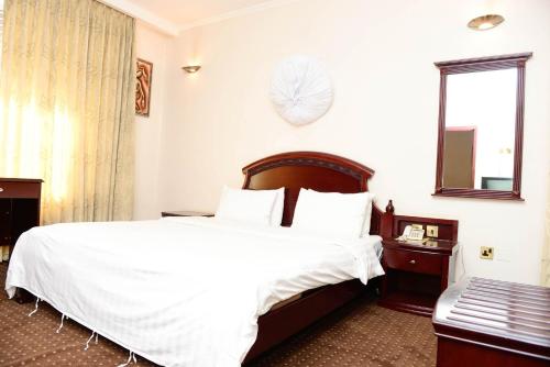 キガリにあるHave a wonderful stay in your Junior Suite wail in Kigaliの大きな白いベッドと窓のある寝室