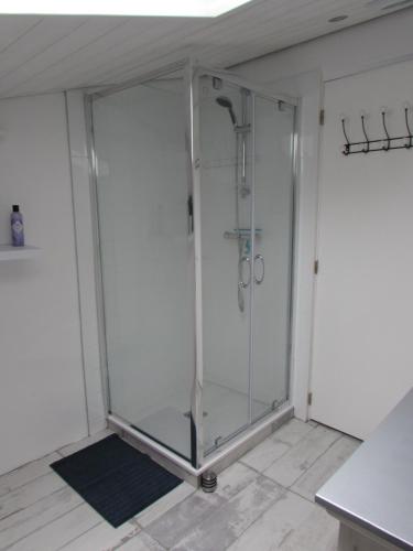 Cette chambre dispose d'une douche en verre et de carrelage. dans l'établissement Le Parc - Suite climatisée, à Magrie