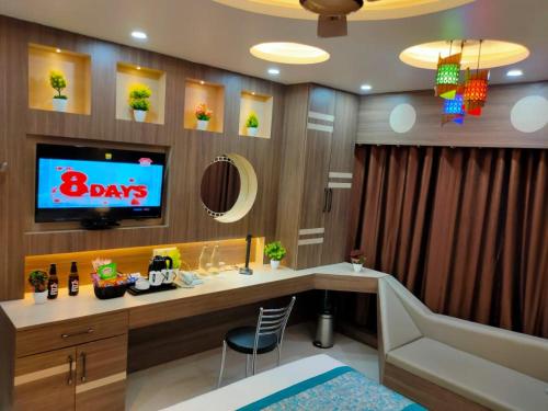 a room with a desk with a tv on a wall at HOTEL CENTRAL SQUARE "A Couple Friendly Hotel" in Muzaffarpur