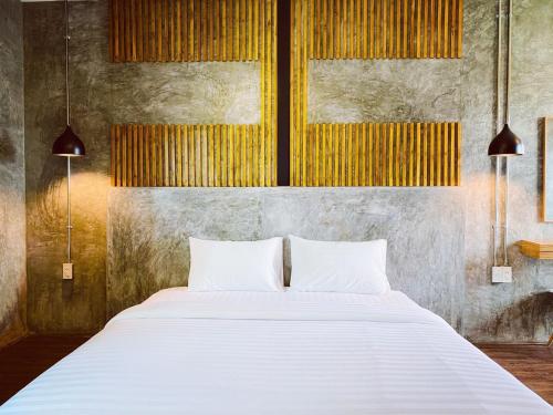 a bedroom with a large bed with two white pillows at Leela Boutique (ลีลาบูทีค) in Nan