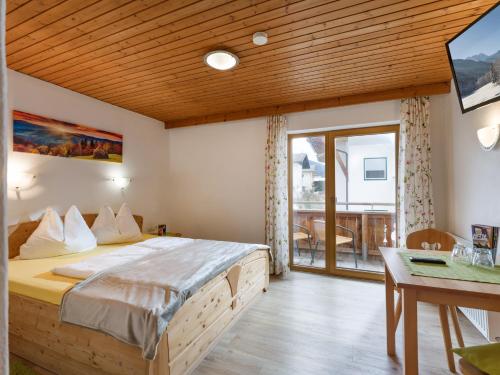 a bedroom with a large bed and a balcony at Gästehaus Hochstaffl in Gerlos