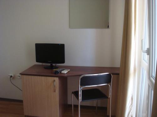 a desk with a computer monitor and a chair at Ivatea Family Hotel in Ravda