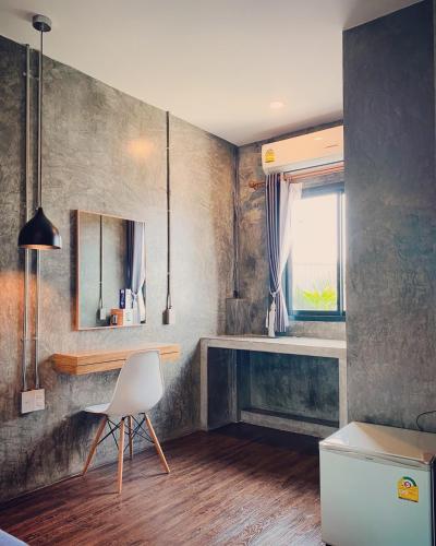 a room with a white chair and a window at Leela Boutique (ลีลาบูทีค) in Nan