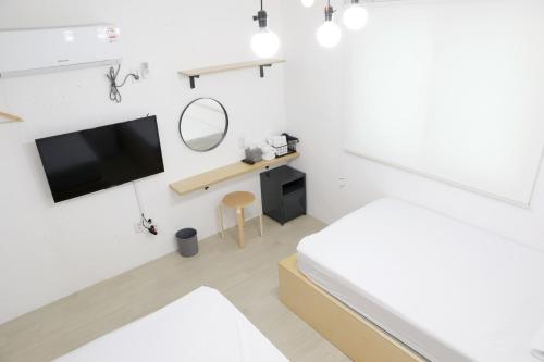 a bedroom with a bed and a tv on a wall at Minihotel Poongdaengi in Gyeongju