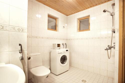 ein Badezimmer mit einem WC und einer Waschmaschine in der Unterkunft Levi President Välirakka Chalet in Levi