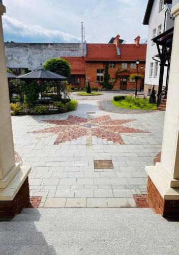 a stone courtyard with an umbrella and buildings at Zoloto Karpat in Stryi