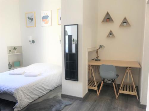 a bedroom with a bed and a desk and a mirror at Modernité cœur du centre-ville in Auxerre