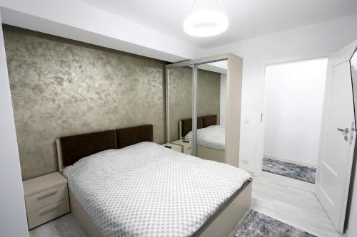 a bedroom with a bed and a mirror at SIF Residence in Craiova