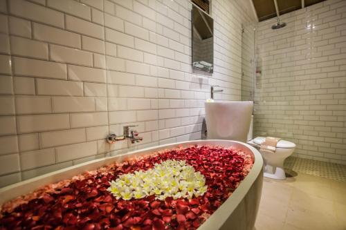 a bathroom with a tub filled with red peppers at Puri Lumbung Village in Payangan