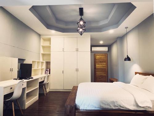a bedroom with a bed and a desk with a computer at Leela Boutique (ลีลาบูทีค) in Nan