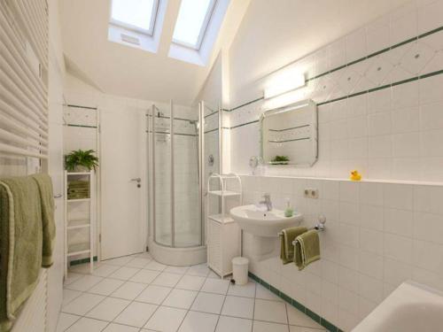 a white bathroom with a sink and a shower at Ferienwohnung Linde in Bad Endorf
