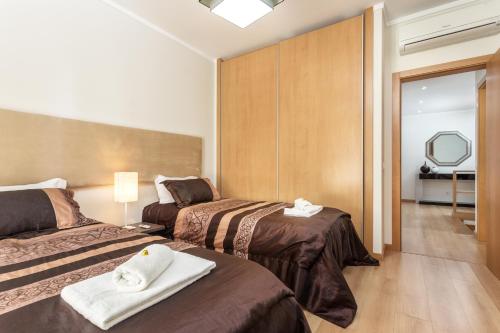 a hotel room with two beds and a mirror at Privilege Apartment Wanseta with Rooftop Pool, Village Marina - Olhão in Olhão