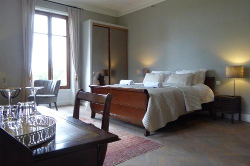 een slaapkamer met een groot bed en een tafel bij Chateau Breduriere in Moutiers-sur-le-Lay