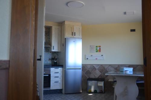 a kitchen with a stainless steel refrigerator and a counter at Casa Rural & SPA Mirador Gredos in Guijo de Ávila