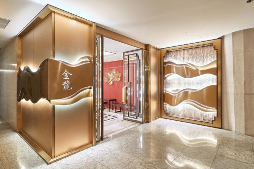 an elevator lobby with gold doors and a table at Grand Walkerhill Seoul in Seoul