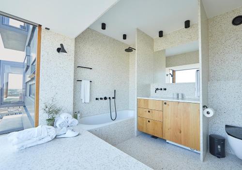 a bathroom with a tub and a sink at Charlottehaven in Copenhagen