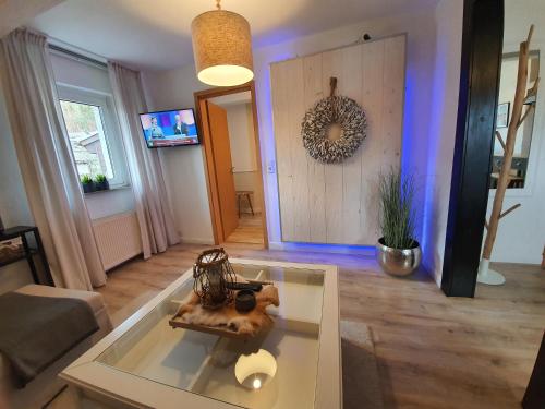 a living room with a glass table and a door at Pension Reinhardshäusle in Reinhardshausen