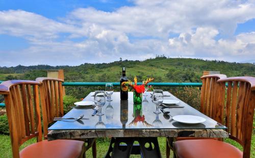 een tafel met een fles wijn en glazen erop bij Heritage Resort Coorg in Madikeri