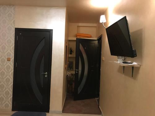 a room with two black doors and a television at Pensiunea exotic in Craiova
