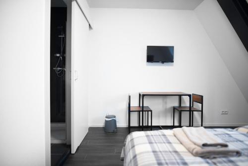 a bedroom with a bed and a table with two chairs at B&B Hotel Lichtstad in Eindhoven