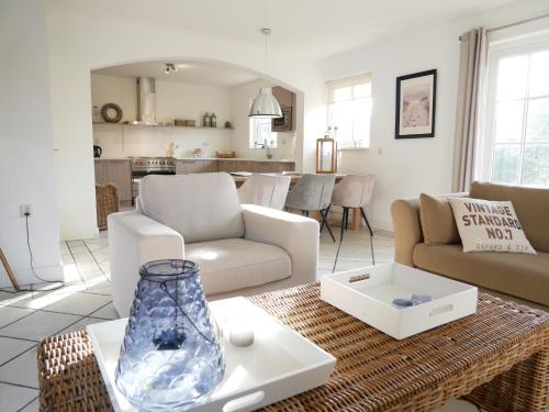 a living room with a couch and a table at Buitenplaats Villa Deluxe in Callantsoog