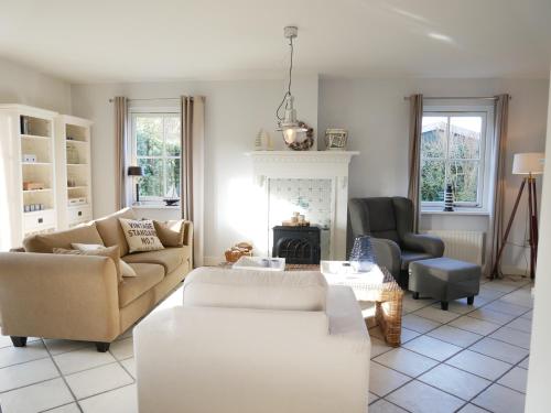 a living room with two couches and a fireplace at Buitenplaats Villa Deluxe in Callantsoog