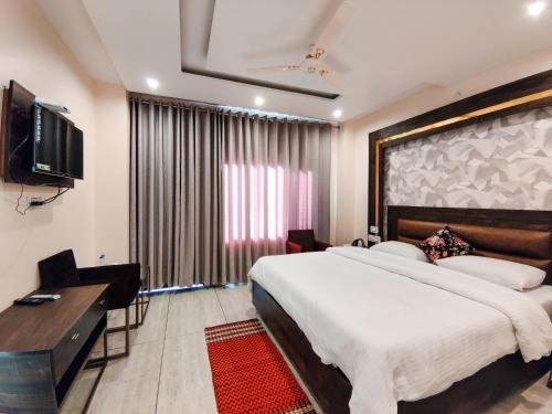 1 dormitorio con 1 cama grande y TV en Golden Rock, Dharamshala - AM Hotel Kollection, en Dharamshala