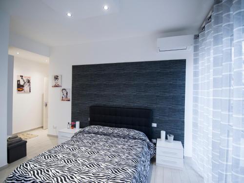 a bedroom with a bed and a black wall at IL MELOGRANO HOLIDAY COMO in Como