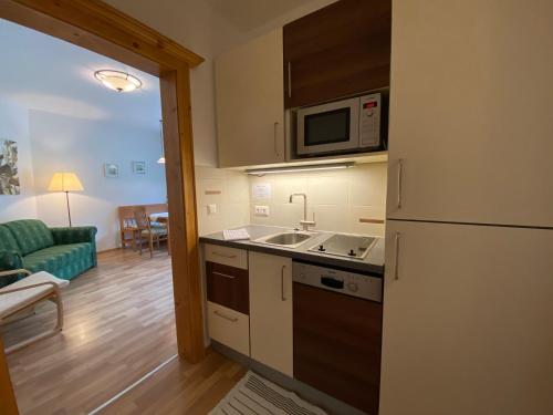 a kitchen with a sink and a microwave at Apart-Pension Wesenauerhof in Fuschl am See