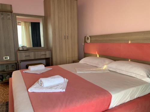 Habitación de hotel con 2 camas y toallas. en Hotel Odhisea Qeparo, en Qeparo