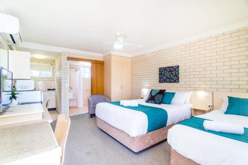 a hotel room with two beds and a kitchen at Santa Fe Motel and Holiday Units in Lennox Head