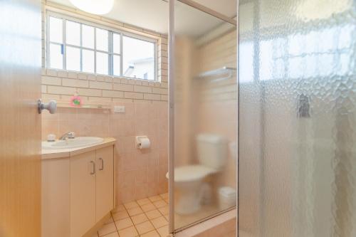 a bathroom with a shower and a sink and a toilet at Santa Fe Motel and Holiday Units in Lennox Head