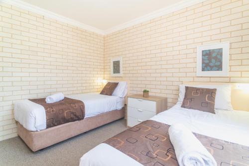 two beds in a room with two beds sidx sidx sidx at Santa Fe Motel and Holiday Units in Lennox Head