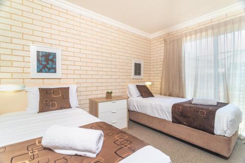 a bedroom with two beds and a window at Santa Fe Motel and Holiday Units in Lennox Head