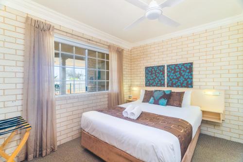 a bedroom with a bed and a window at Santa Fe Motel and Holiday Units in Lennox Head