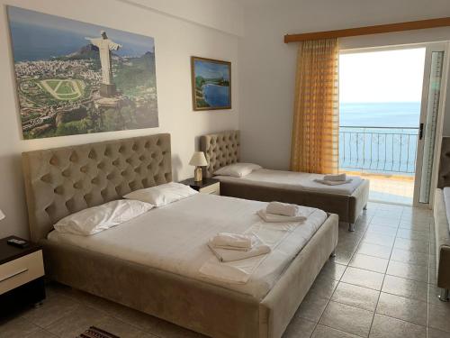 1 dormitorio con 2 camas y una cruz en la pared en Hotel Odhisea Qeparo, en Qeparo