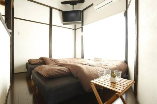 a bedroom with a large bed and a table at アンドステイ西早稲田3丁目B in Tokyo