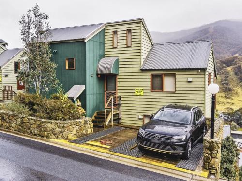 a car parked in front of a house at Banjo 4 Two Bedroom with Loft real fireplace and mountain views in Thredbo