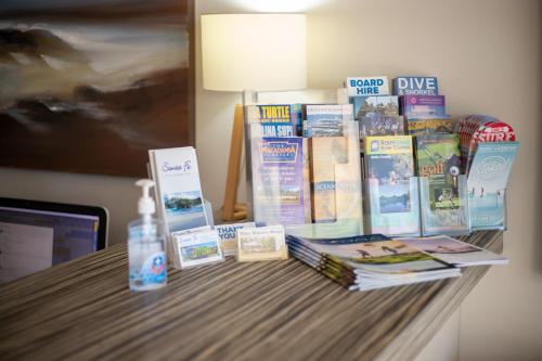 a table with books and a bottle of water on it at Santa Fe Motel and Holiday Units in Lennox Head