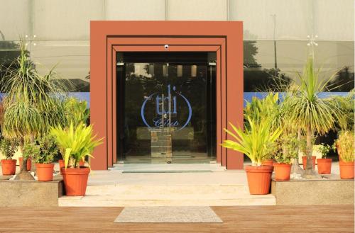 a door to a building with potted plants in front of it at TDI Club Retreat Kundli in Sonīpat