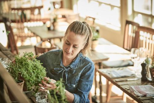 a woman sitting at a table holding a bunch of greens at Knistad Herrgård in Skövde