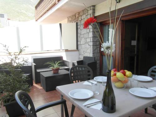 a table with plates and a vase of flowers on it at Apartamentos Los Lagos in Benasque