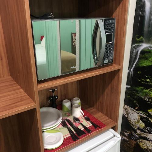 a microwave oven sitting on top of a cabinet at Pousada Vó Liane in Praia Grande