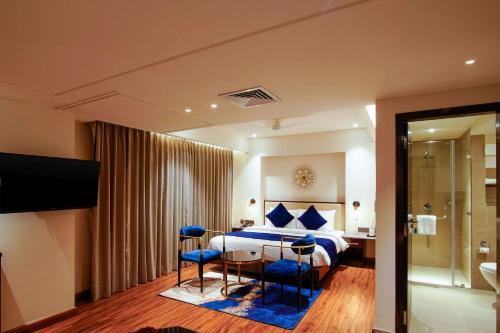 a bedroom with a bed and a table and chairs at Comfort Inn Dehradun in Dehradun