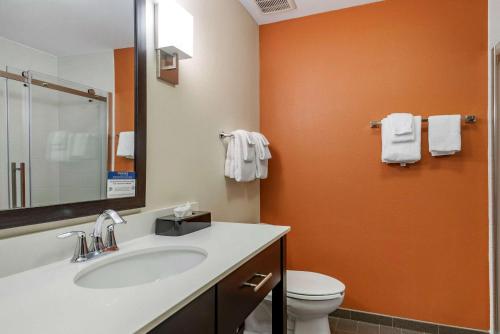 an orange bathroom with a sink and a toilet at Sleep Inn & Suites Moab near Arches National Park in Moab