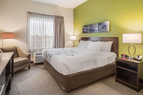 um quarto de hotel com uma cama e uma cadeira em Sleep Inn em Union City