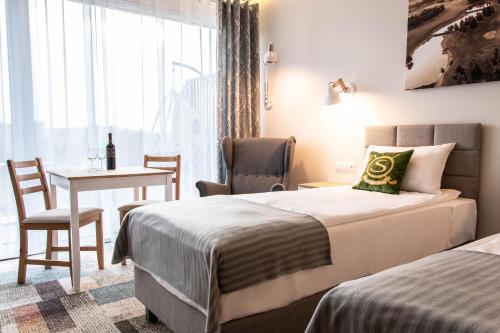 a hotel room with two beds and a table at Bungalows at Sierra Golf Resort in Wejherowo